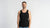 Man wearing a black tank top against a plain background