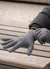 Man outdoors with dark gray knitted merino wool gloves.